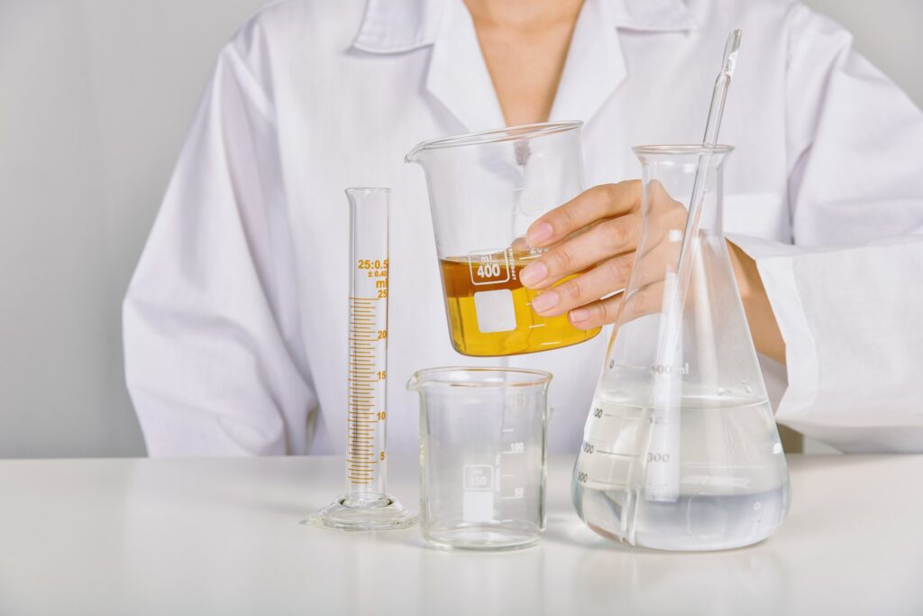 Scientist holding oil beaker, Laboratory and science experiments, Formulating the chemical